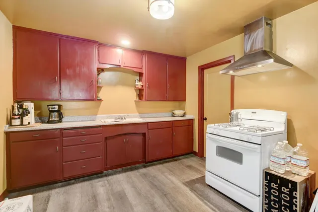 a kitchen with a stove a sink and cabinets