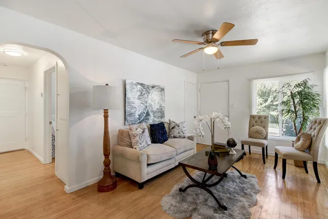 a living room with furniture and a wooden floor