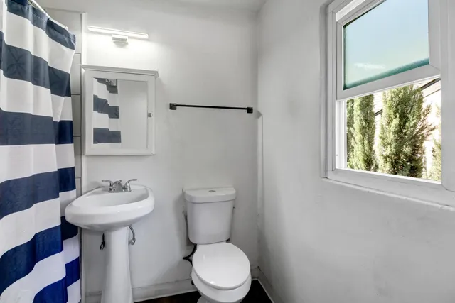 a bathroom with a sink toilet and a mirror