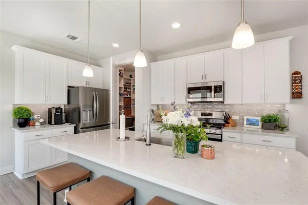 a kitchen with stainless steel appliances a sink refrigerator and microwave