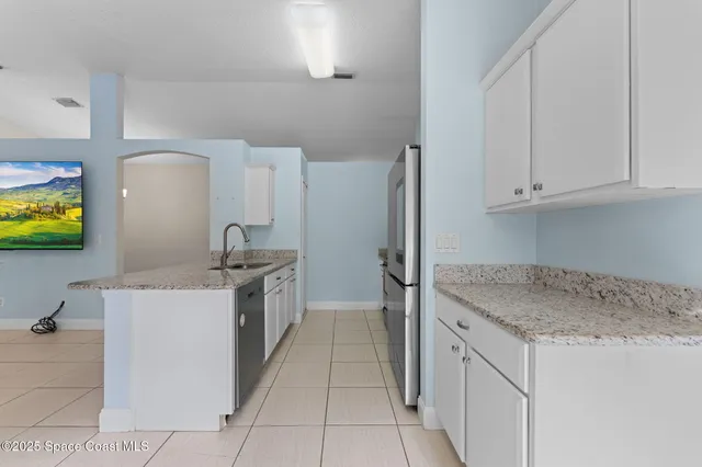 a kitchen with stainless steel appliances granite countertop a sink and a stove top oven