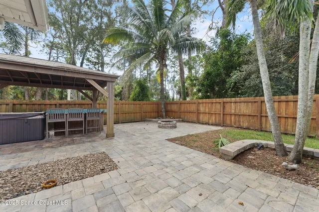 a view of backyard with wooden fence and trees