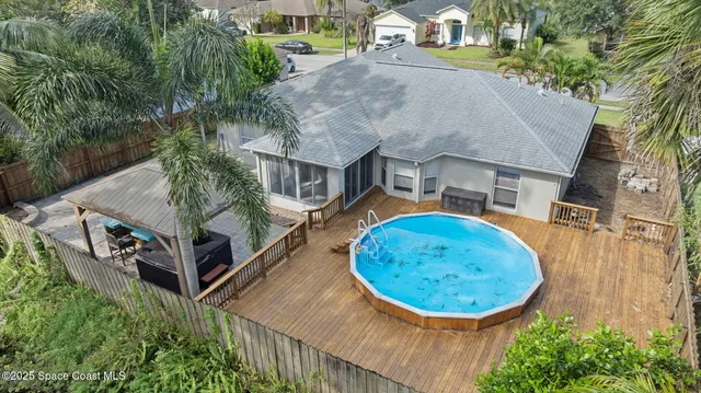 an aerial view of residential houses with outdoor space and trees
