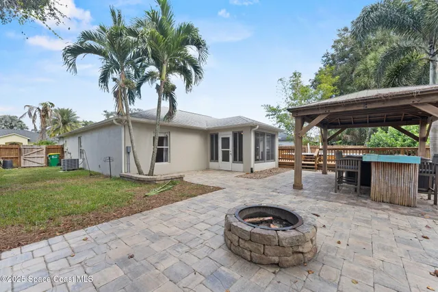 a backyard of a house with barbeque oven and outdoor seating