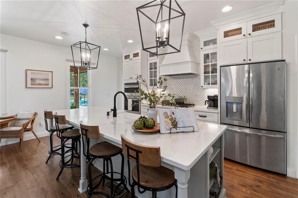 1273 Villa Rica Road Powder Springs, GA 30127 - Photo 23 of 69 a kitchen with stainless steel appliances granite countertop a dining table chairs and wooden floor