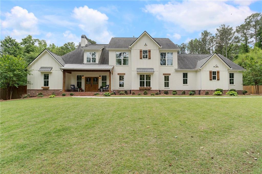 1273 Villa Rica Road Powder Springs, GA 30127 - Photo 4 of 69 a front view of a house with a garden and yard