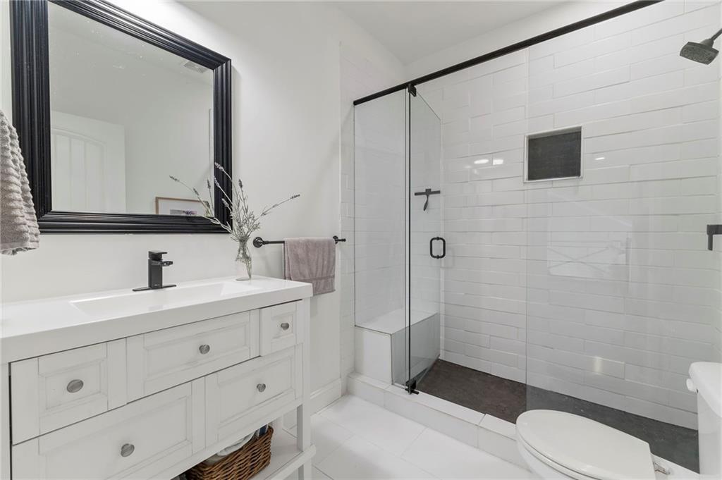 1273 Villa Rica Road Powder Springs, GA 30127 - Photo 52 of 69 a bathroom with a toilet a sink a mirror and shower