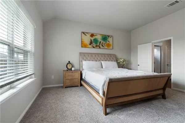 a bedroom with a bed and a painting on the wall