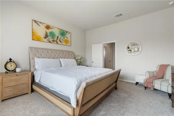 a bed room with a bed and painting on the wall