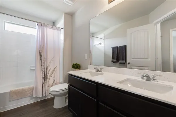 a bathroom with a double vanity sink toilet and shower