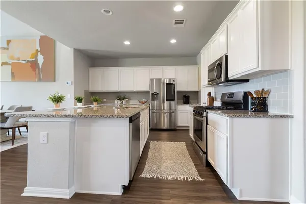 a kitchen with granite countertop a sink and cabinets