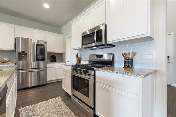 a kitchen with stainless steel appliances granite countertop a refrigerator stove a microwave oven a sink and dishwasher