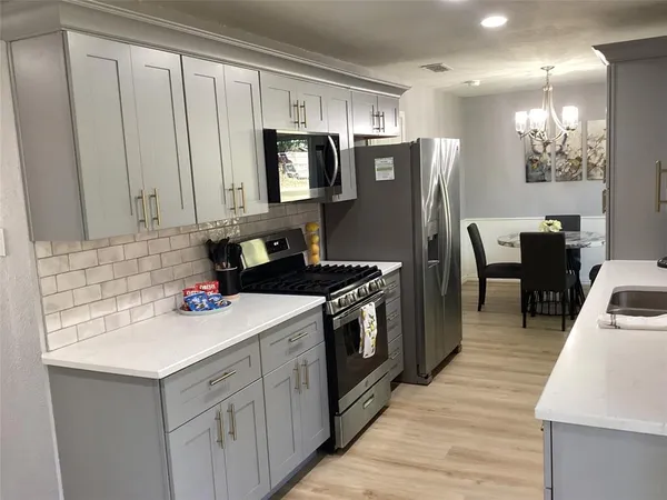 a kitchen with a sink cabinets and wooden floor