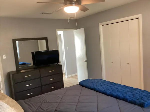 a bedroom with a bed and a mirror on dresser