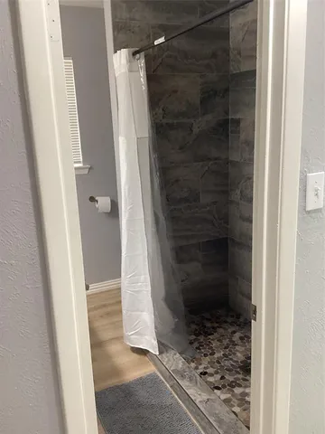 a bathroom with a glass door shower and a sink