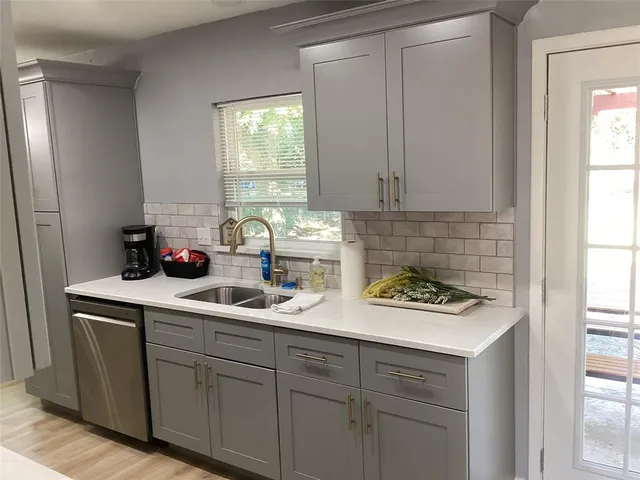 a kitchen with white cabinets and window