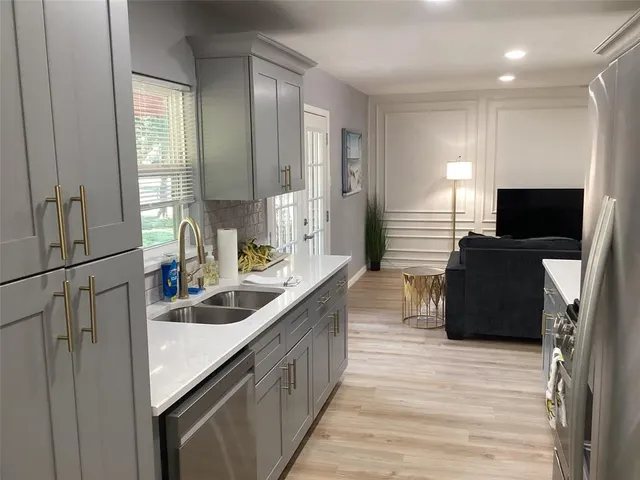 a kitchen with kitchen island stainless steel appliances a sink stove and refrigerator
