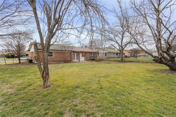 a view of a house with a big yard and large trees