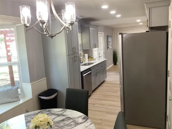 a kitchen with stainless steel appliances a refrigerator and a wooden floor