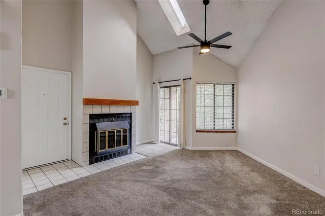an empty room with windows and fireplace