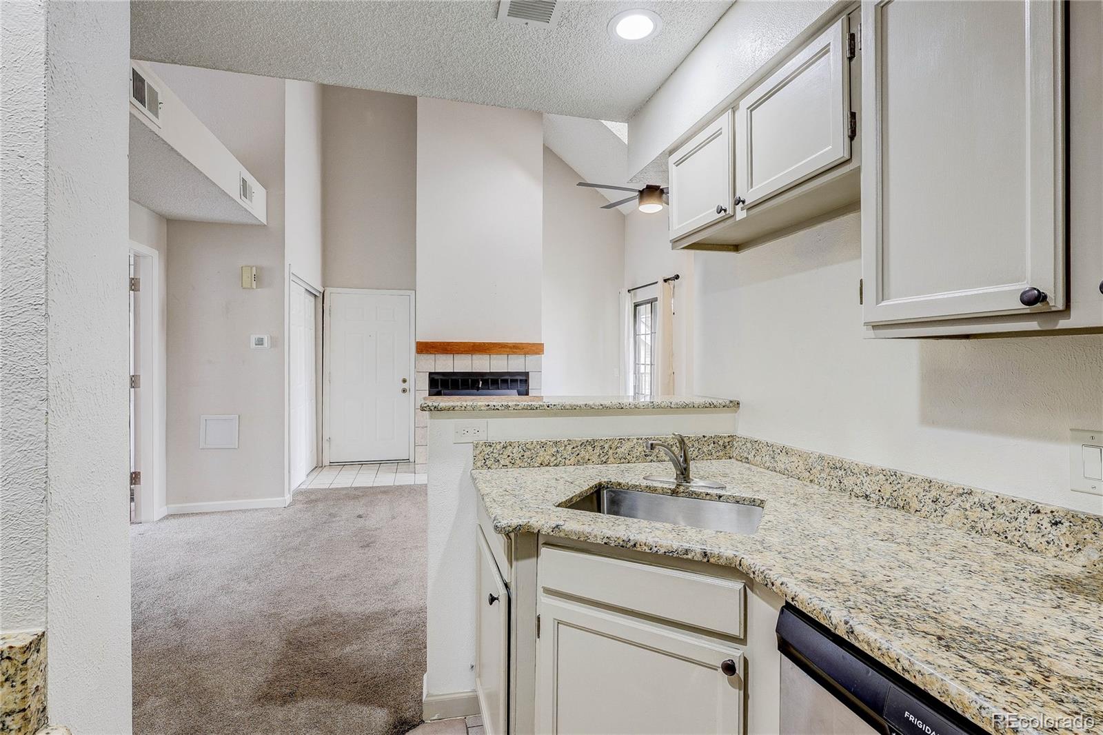 4824 East Kentucky Avenue, Unit C Denver, CO 80246 - Photo 6 of 17 a kitchen with granite countertop a sink and cabinets