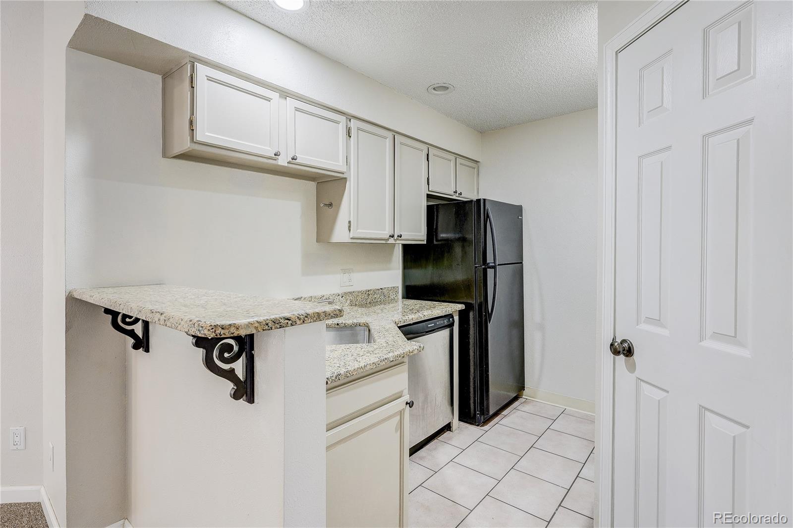 4824 East Kentucky Avenue, Unit C Denver, CO 80246 - Photo 7 of 17 a kitchen with a stove refrigerator and cabinets