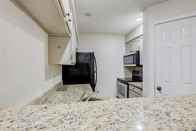a view of a livingroom with wooden floor and workspace