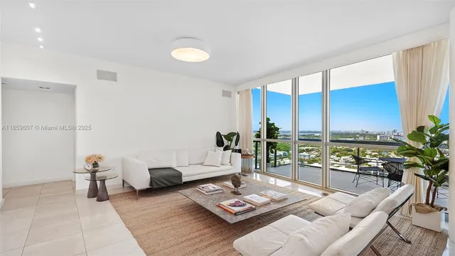 a living room with furniture and floor to ceiling window