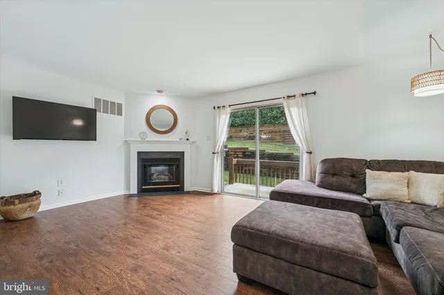 a living room with furniture a large window and a fireplace