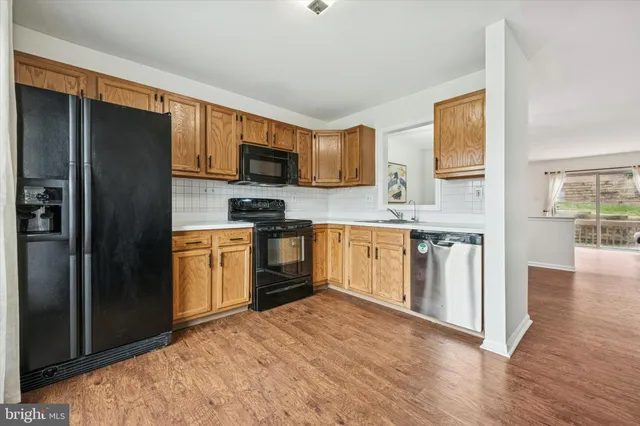 a kitchen with stainless steel appliances granite countertop a refrigerator stove top oven and sink