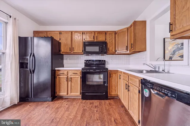 a kitchen with granite countertop a refrigerator stove and sink