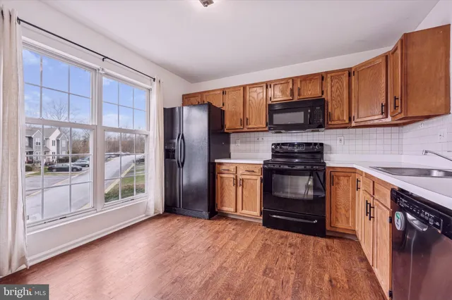 a kitchen with stainless steel appliances granite countertop a refrigerator stove and sink