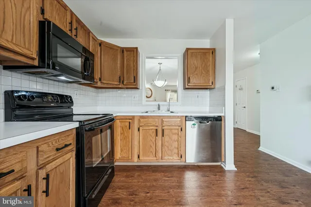 a dining room with wooden floor a chandelier a wooden table and chairs