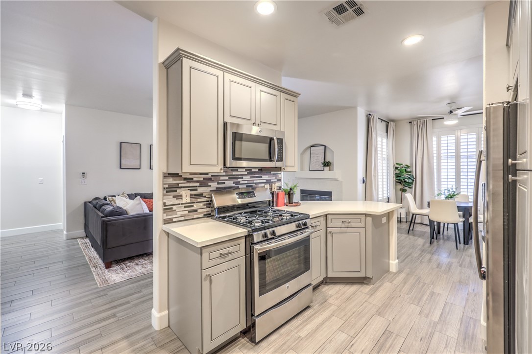 2050 West Warm Springs Road, Unit 1421 Henderson, NV 89014 - Photo 19 of 45 A well-appointed kitchen showcasing modern appliances and stylish cabinetry, seamlessly flowing into a bright dining area.