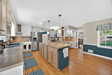 a large kitchen with stainless steel appliances granite countertop a stove oven and a refrigerator