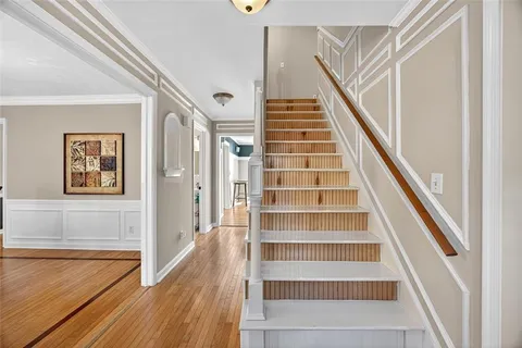 a view of staircase with wooden floor and white walls