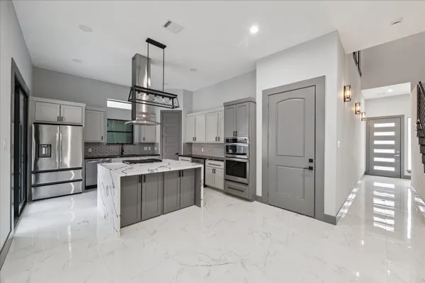 a kitchen with kitchen island stainless steel appliances a stove center island and cabinets