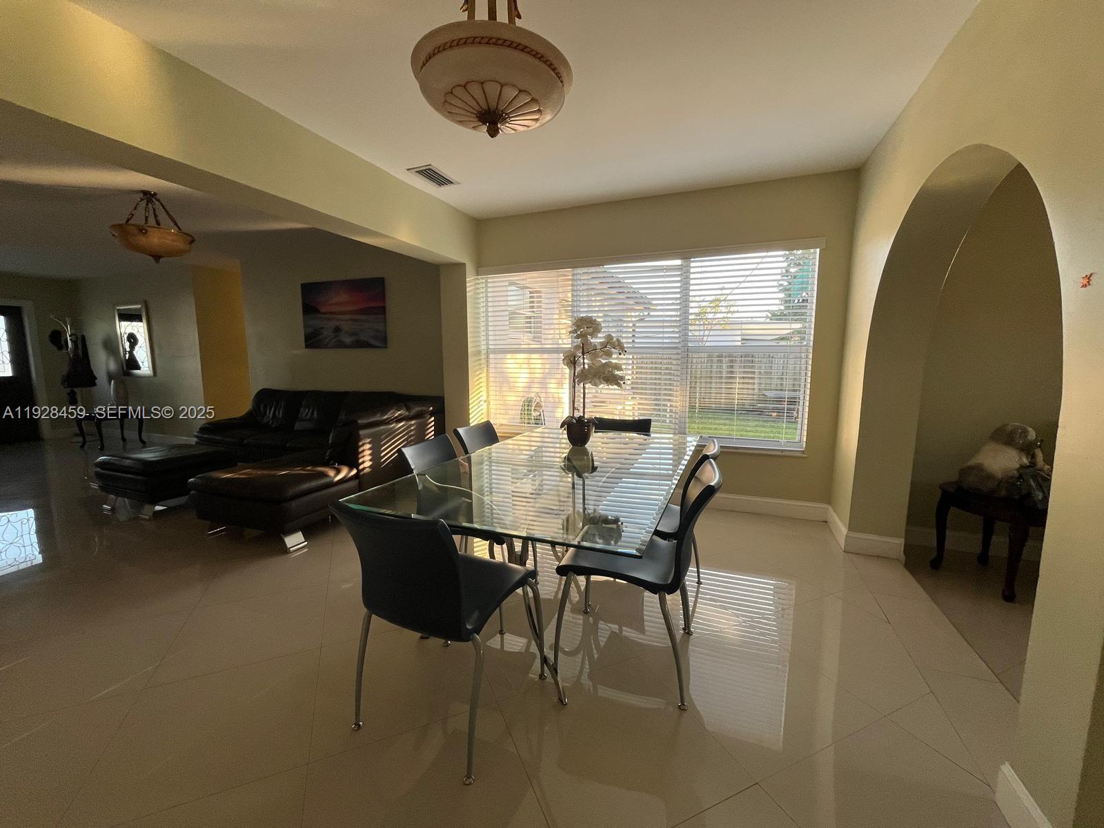 3520 Southwest 104th Avenue Miami, FL 33165 - Photo 11 of 38 a living room with furniture a flat screen tv and a large window