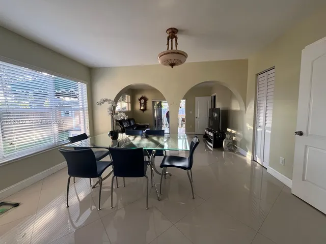 a living room with furniture a flat screen tv and a large window