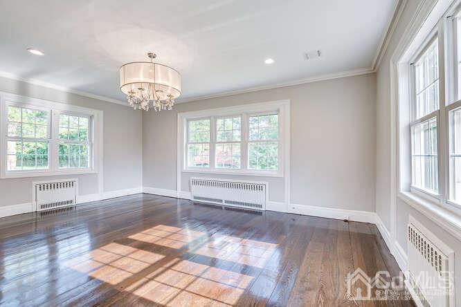 55 Devon Road, Unit B Colonia, NJ 07067 - Photo 11 of 53 a view of an empty room with wooden floor and a window