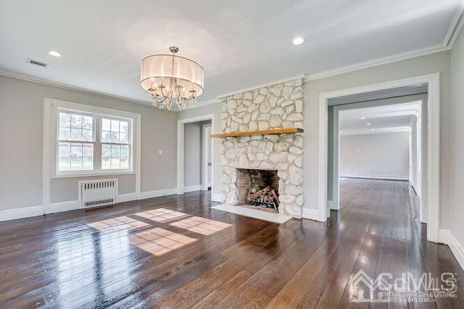 55 Devon Road, Unit B Colonia, NJ 07067 - Photo 15 of 53 a view of an empty room with wooden floor fireplace and a window