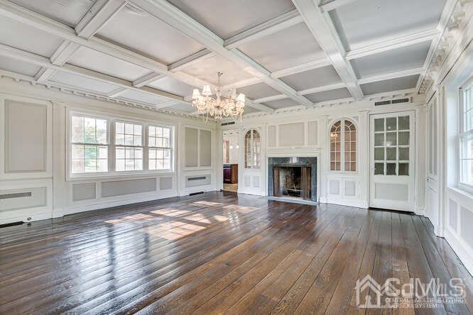 55 Devon Road, Unit B Colonia, NJ 07067 - Photo 17 of 53 a view of an empty room with wooden floor fireplace and a window