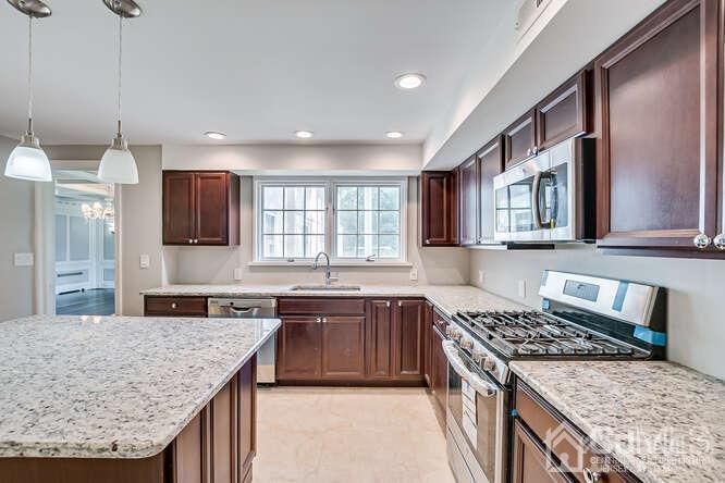 55 Devon Road, Unit B Colonia, NJ 07067 - Photo 24 of 53 a kitchen with stainless steel appliances granite countertop wooden cabinets stove and granite counter tops