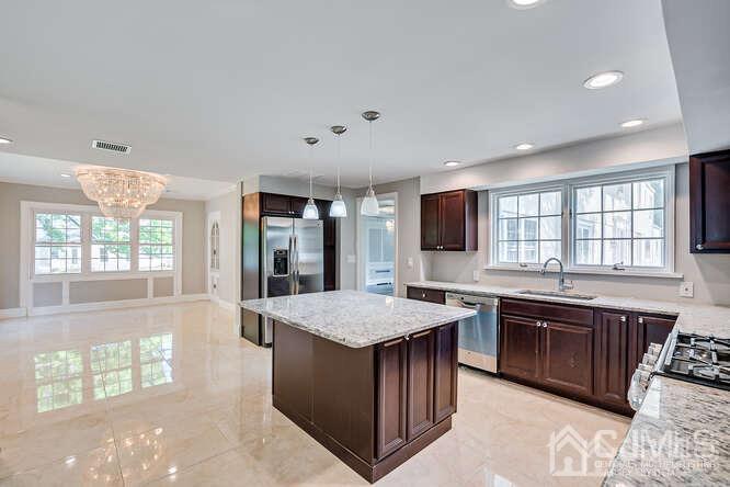 55 Devon Road, Unit B Colonia, NJ 07067 - Photo 25 of 53 a large kitchen with stainless steel appliances granite countertop a stove and a sink