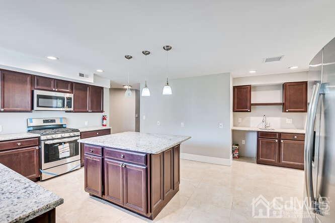 55 Devon Road, Unit B Colonia, NJ 07067 - Photo 26 of 53 a kitchen with stainless steel appliances granite countertop a stove top oven a sink and a refrigerator