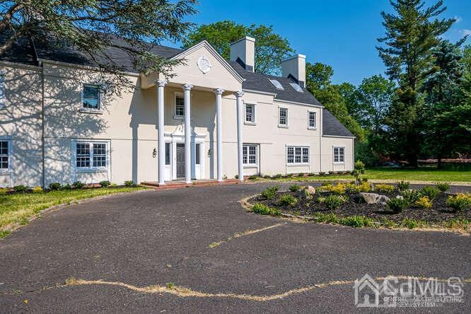 55 Devon Road, Unit B Colonia, NJ 07067 - Photo 3 of 53 a view of a white house with a yard and potted plants