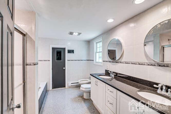 55 Devon Road, Unit B Colonia, NJ 07067 - Photo 33 of 53 a spacious bathroom with a double vanity sink double mirror and a toilet