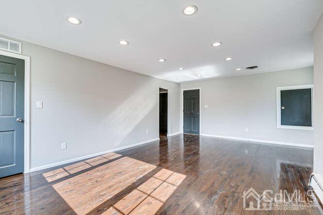 55 Devon Road, Unit B Colonia, NJ 07067 - Photo 40 of 53 an empty room with wooden floor and workspace