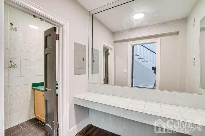 55 Devon Road, Unit B Colonia, NJ 07067 - Photo 8 of 53 a bathroom with a granite countertop sink and a mirror