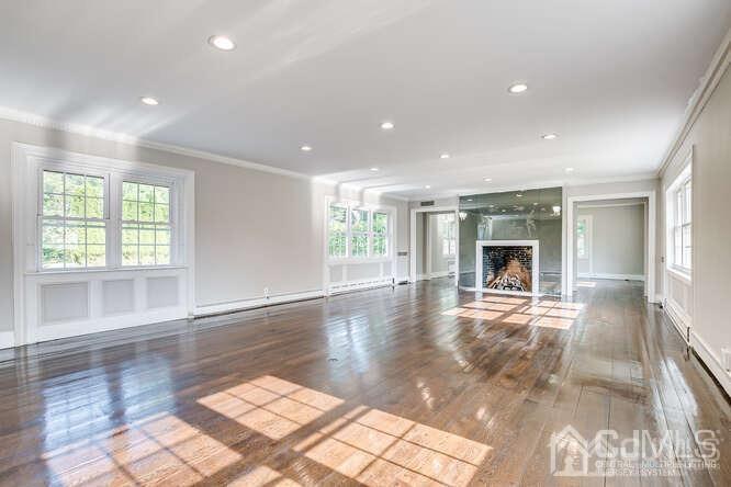 55 Devon Road, Unit B Colonia, NJ 07067 - Photo 9 of 53 a view of empty room with wooden floor and fireplace